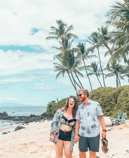 Couple laughing and holding hands on the beach in Maui, Hawaii